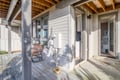 Step onto your private covered porch where weathered wood beams frame peaceful moments on the swing chair.