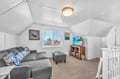 Cozy up in this charming attic living room where ocean-themed decor and comfortable seating create your perfect relaxation retreat.