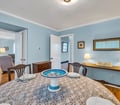 Gather around this charming dining table where warm blue walls create a peaceful setting for your morning coffee or evening meals with loved ones.