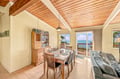 Gather around the dining table under vaulted wood ceilings while breathtaking ocean views frame your meals through expansive glass doors opening to the deck.