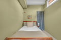 Your peaceful bedroom features soft green walls, cozy linens, and gentle natural light streaming through the skylight above—perfect for restful nights and rejuvenating mornings.