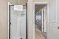 Your private shower features crisp white fixtures and fresh towels, connecting to the hallway for easy access throughout your stay.