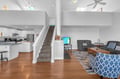 Bright open-plan living where you'll relax in comfort with soaring ceilings, warm hardwood floors, and modern kitchen nearby.