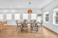 Gather around this stylish dining table where you'll share meals and create memories in the bright, modern space with natural light streaming through.