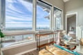 Sink into your comfortable recliner and soak up breathtaking panoramic views through floor-to-ceiling windows in this bright, airy living space.
