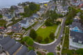 Charming coastal neighborhood with beach access and Victorian-style homes nestled among tree-lined streets near the shoreline.