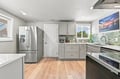 Step into this beautifully renovated kitchen where sleek gray cabinetry meets ocean-toned backsplash, creating a calming space perfect for preparing your morning coffee or cooking up a homemade feast.