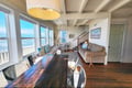 Gather around the dining table or relax on the couch as the ocean stretches out before you through floor-to-ceiling windows, filling your beachfront retreat with natural light and coastal charm.