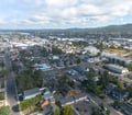 An aerial perspective of a charming coastal town nestled between river, bay, and mountain backdrop—a peaceful setting for exploring local neighborhoods and natural beauty.