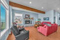 Unwind in your spacious living room where plush red sofas face a cozy stone fireplace, perfect for evening gatherings.