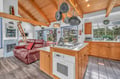 Settle into this spacious open-plan retreat where rustic wood beams meet modern comfort—your perfect cooking and relaxation sanctuary.