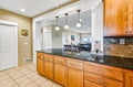 Step into your open kitchen and dining space, where granite countertops and warm wood cabinetry set the stage for memorable meals together, all with ocean views just beyond.