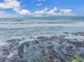 Dramatic ocean waves crash against rugged coastal rocks under brilliant blue skies, creating a stunning natural seascape near the property.