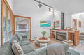 Unwind in your cozy living room featuring a warm fireplace, plush seating, and tropical art that sets the perfect mood for relaxation.