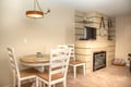 Gather around the cozy dining table and enjoy meals by the warm glow of your private fireplace in this inviting space.