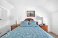 Rest peacefully in your charming bedroom with soft blue linens and warm wood furnishings creating the perfect retreat.