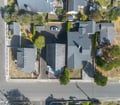 Aerial view showing the property set in a quiet residential neighborhood with tree-lined streets and nearby houses in the surrounding area.