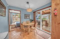 Picture yourself enjoying morning coffee at this charming wooden table, sunlight streaming through open doors to your private deck. The cozy space flows effortlessly from dining inside to grilling and relaxing outdoors, creating your perfect mountain retre