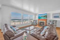 Sink into plush leather seating and watch waves crash beyond your floor-to-ceiling windows. The cozy fireplace creates perfect ambiance for seaside evenings.