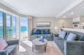 Sink into plush sofas as turquoise waters sparkle just beyond your balcony, framing your perfect beach escape.