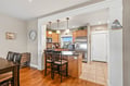 Step into your welcoming open-concept space where warm wood floors flow seamlessly from dining to kitchen. Gather at the breakfast bar or prepare meals in your fully equipped kitchen with gleaming countertops and modern appliances.