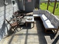 Your private patio invites relaxation with plush seating and wooden chairs, perfect for morning coffee or evening conversations under natural shade.