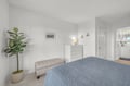 Relax in your serene bedroom, styled in soothing coastal tones, complete with a cozy bench, soft lighting, and a connecting ensuite bathroom for your convenience and comfort.