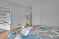 Drift off in your bright bedroom with ocean-themed bedding, natural light, and glimpses of the kitchen's modern conveniences nearby.
