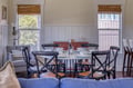 Your bright dining space awaits with a welcoming table set for memorable meals together, framed by charming windows and cozy seating areas for relaxing before or after your gatherings.