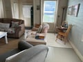 Unwind in your cozy living room with comfortable seating and natural light streaming through the windows for the perfect retreat.