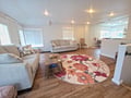 Relax in your spacious living room with plush sofas and beautiful hardwood floors, where natural light streams through windows.