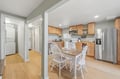 Your fully equipped kitchen features warm wood cabinetry, stainless steel appliances, and a cozy dining table perfect for home-cooked meals and morning coffee together.