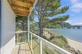 Step out onto your private balcony and let the serene water views wash over you. The gentle rustle of coastal pines and the calm shoreline create a peaceful retreat where every morning feels like a fresh start.