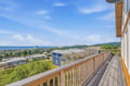 Elevated deck offers sweeping coastal and mountain vistas, placing guests in a scenic Oregon beach community setting with ocean rock formations visible in the distance.
