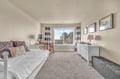 Your bright bedroom features a cozy daybed, work desk, and dresser with natural light streaming through large windows.