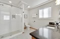 Step into your spa-like bathroom with gleaming granite counters, a glass-enclosed shower, and crisp white fixtures bathed in natural light.