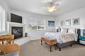 Unwind in your coastal bedroom, complete with a cozy fireplace, ceiling fan, and beach-inspired touches that invite peaceful relaxation after long days exploring.