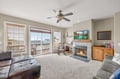 Relax in your cozy living room with crackling fireplace, comfortable seating, and sliding doors opening to your private balcony.