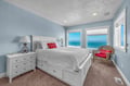 Wake up to stunning ocean views from your peaceful bedroom, where soft blue walls and crisp white furnishings create the perfect coastal retreat.