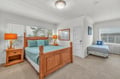 Rest comfortably in your spacious bedroom featuring warm wood furnishings, soft linens, and bright windows that fill the room with natural light.