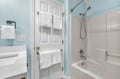 Refresh in your private bathroom with fresh towels, soothing blue walls, and a full tub-shower combo for relaxing soaks or quick rinses.
