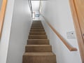 Ascend these comfortable carpeted stairs to reach your private retreat upstairs, where relaxation awaits.