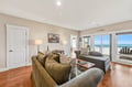 Sink into plush seating and let your gaze drift across endless ocean vistas. Large windows frame the turquoise waters, filling your living space with natural light and coastal serenity.