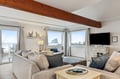 Sink into plush seating while watching waves through panoramic windows in your oceanfront living room.