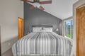 Relax in your cozy bedroom featuring a plush bed, gentle ceiling fan, and peaceful garden views through your private window.