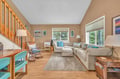 Sink into plush sofas in your bright living room, where natural light streams through large windows and warm wood accents create the perfect retreat.