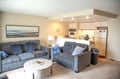 Sink into plush sofas in your open living space, where coastal artwork and a full kitchen invite you to unwind and feel completely at home.