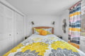 You'll love waking up in this cheerful bedroom with vibrant yellow florals and cozy wicker headboard details.