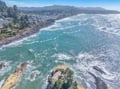 Dramatic coastline with turquoise waters and forested hills creates a stunning backdrop for this coastal community.