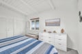 Drift off in your serene bedroom, where crisp blue linens meet bright white beams overhead and morning light streams through your window.